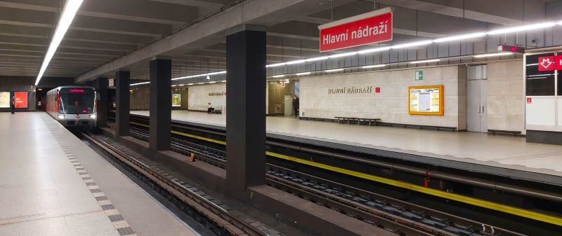 Separate platforms on opposite sides of the tracks at Hlavní nádraží metro station, with a train approaching.