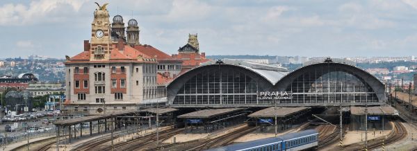 Prague Main Railway Station with parking on the left, historical building and the platforms under the covering cupolas