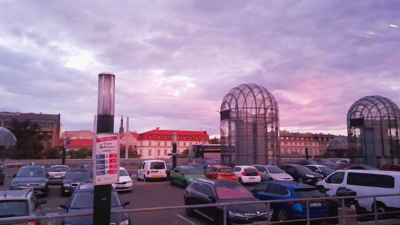 Glass elevator towers in the parking area in front of Prague Main Station’s historic Fantova Building.