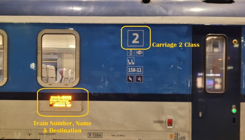 Exterior of a Czech train showing the second-class symbol and an electronic display with the train number, name and destination.